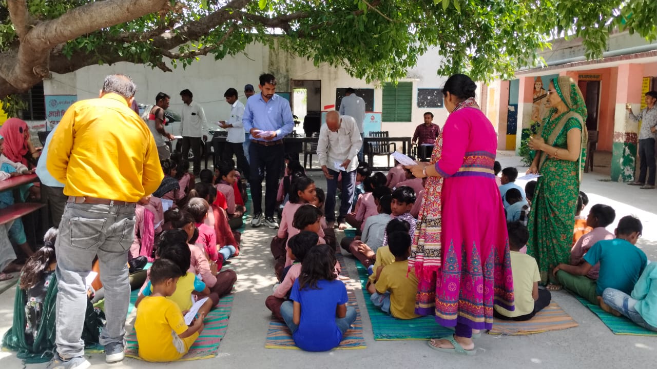 बच्चों को शिक्षा सामग्री वितरण करते हुए।