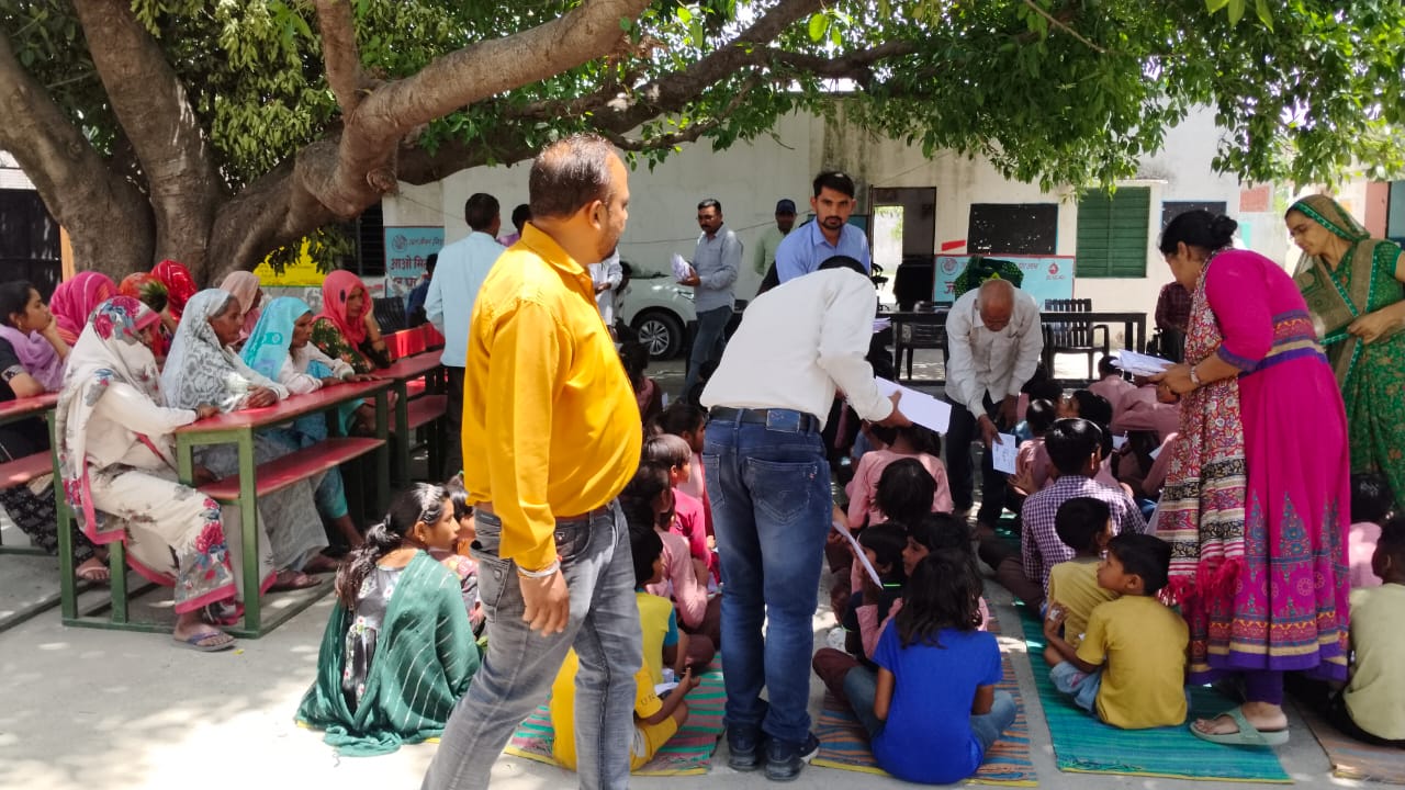 बच्चों को शिक्षा सामग्री वितरण करते हुए।