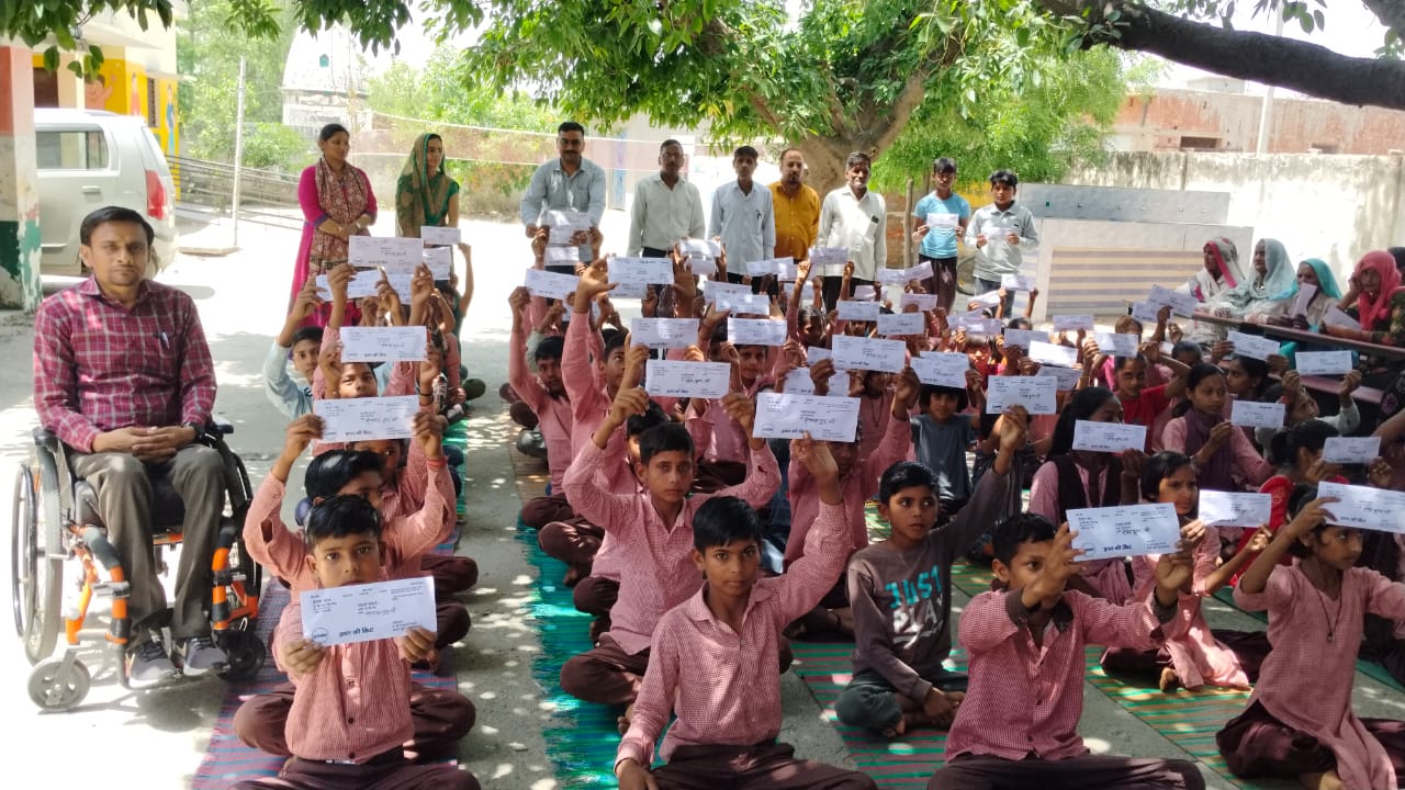 बच्चों को शिक्षा सामग्री वितरण करते हुए।